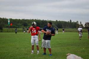 Coach Andres Perez, talks to quarterback Quinten Poteralski about plays the team will be learning at practice. Perez continues to coach the team on when they will next face off against Freedom on October 24th.