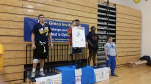 Freshman Juan Bautista, while wearing the championship belt, holds up Greco and his winning bracket. He wrestles in Steinbrenner's 220 pound weight class.